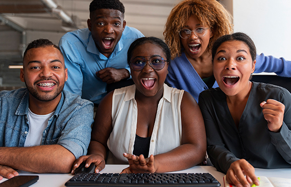 a group of people sitting around a computer